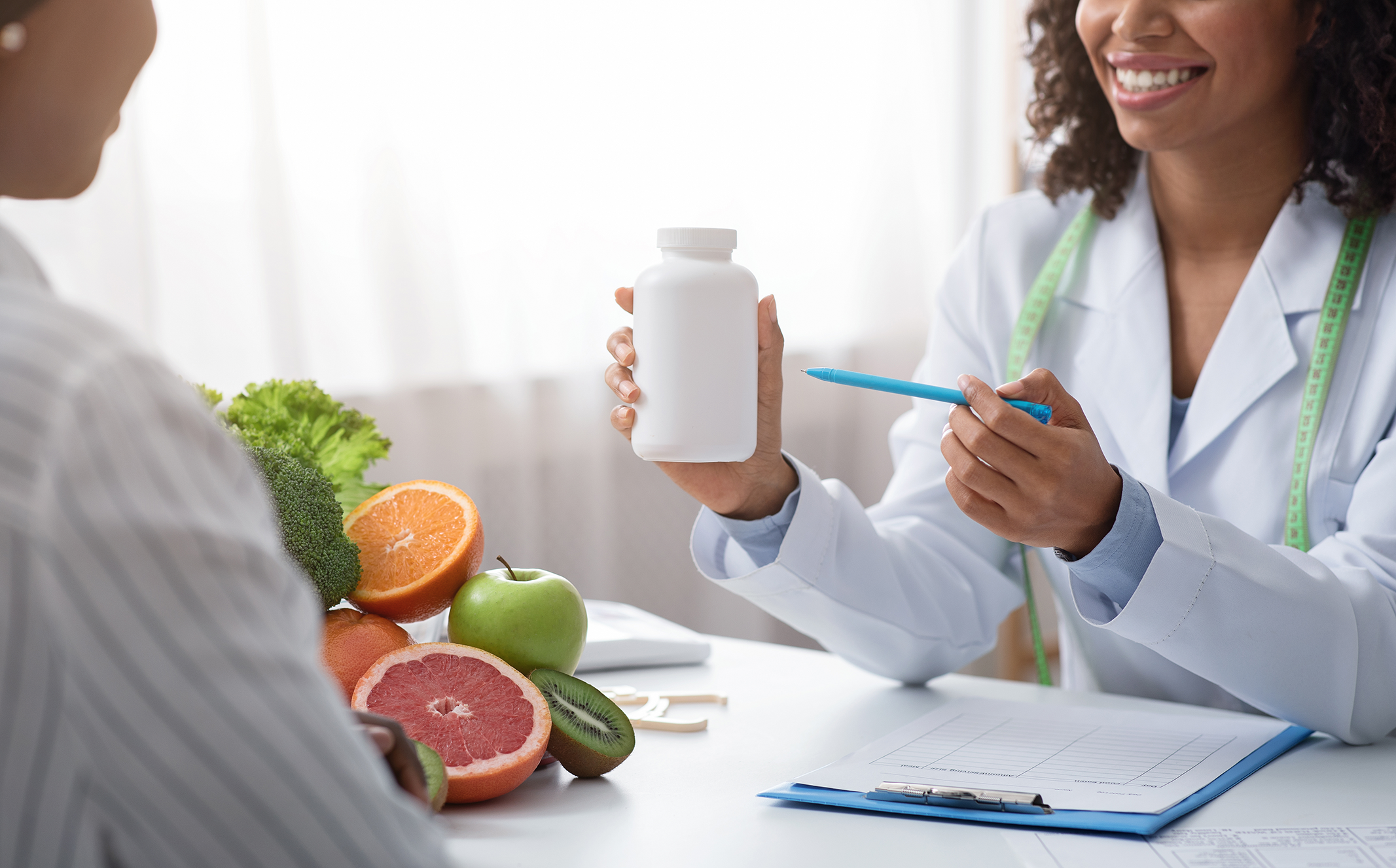 Practitioner showing patient a supplement